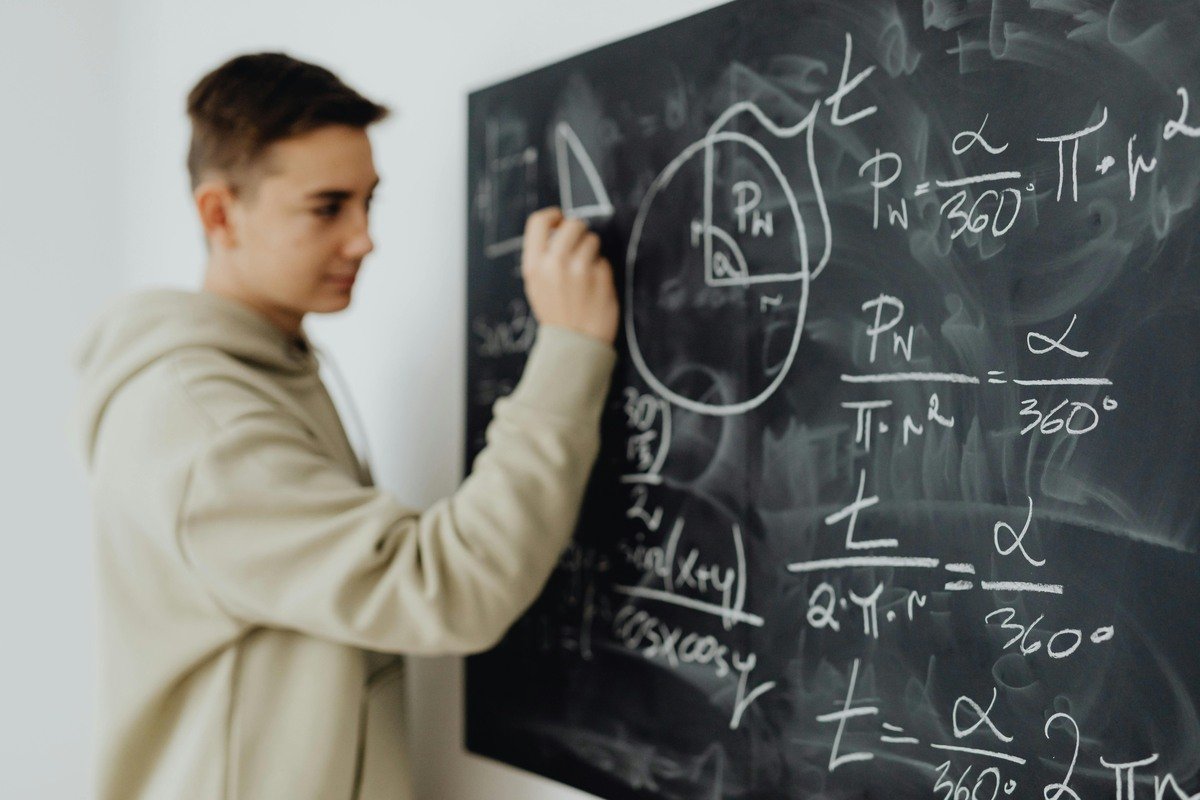 Student solving advanced math problems on a chalkboard related to calculus bc ti-84 programs